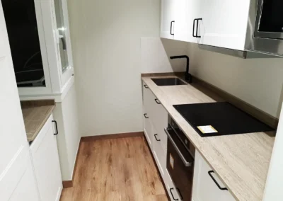Cocina moderna recién reformada con encimeras de madera y electrodomésticos integrados.