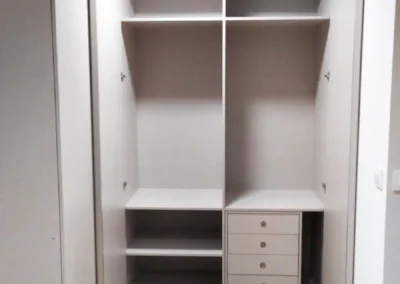 Armario empotrado recién instalado con iluminación integrada en el dormitorio.